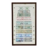 A framed collection of paper money from Iraq - featuring an image of Saddam Hussein in denominations