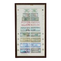 A framed collection of paper money from Iraq - featuring an image of Saddam Hussein in denominations