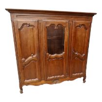 A French 20th century oak armoire - with a central glazed door flanked by a pair of panel doors