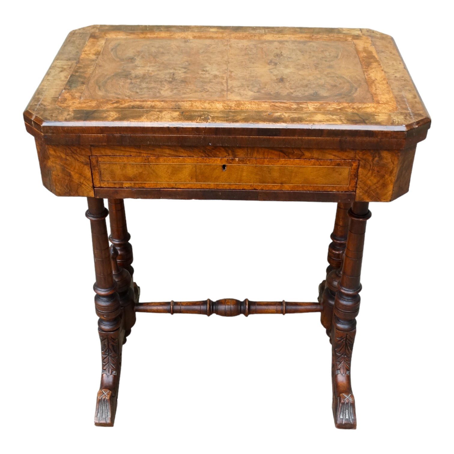 A Victorian walnut games and work table - the hinged rectangular top with canted corners opening