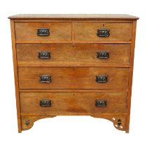 An early 20th century Arts and Crafts style oak chest of drawers - the rectangular top above and