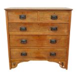An early 20th century Arts and Crafts style oak chest of drawers - the rectangular top above and