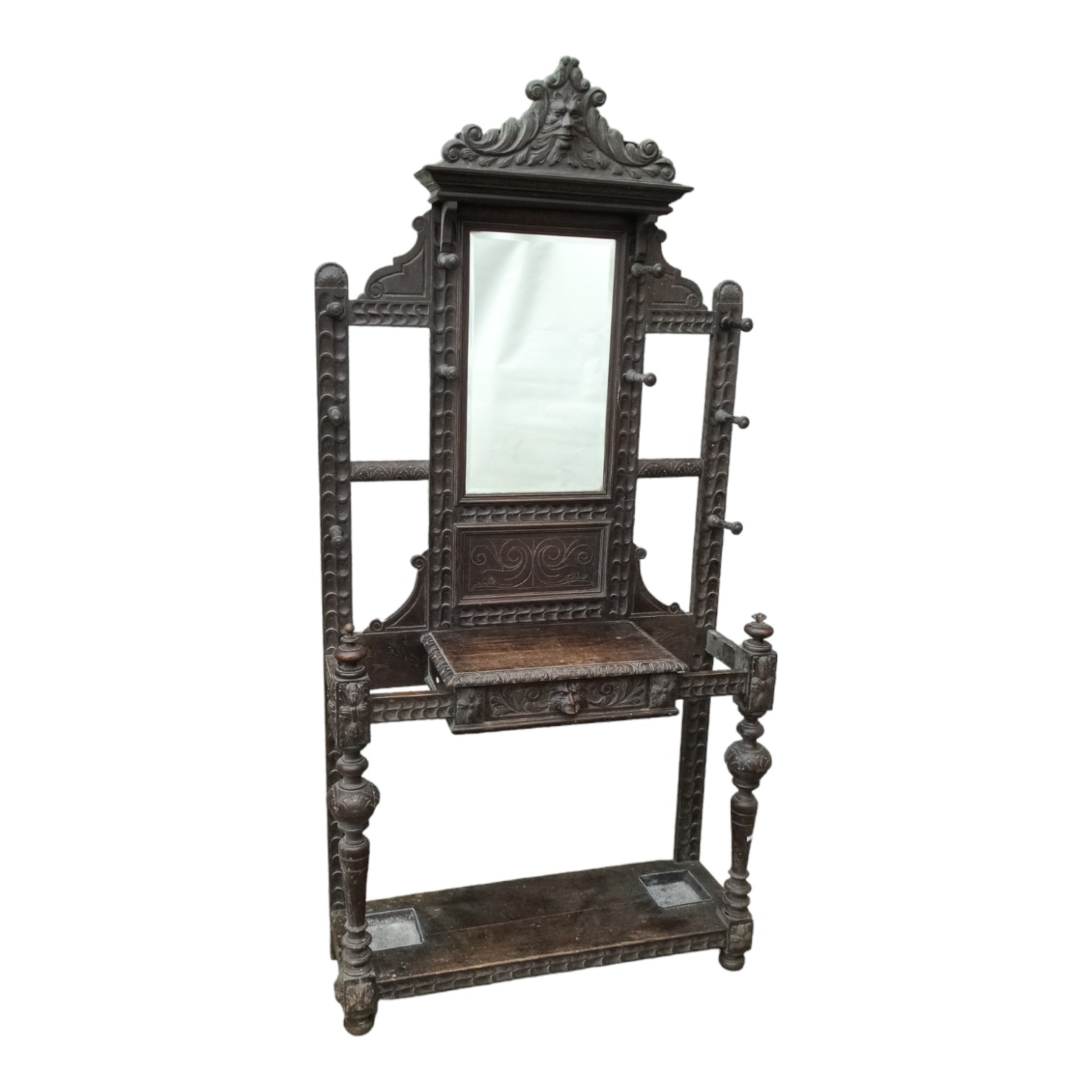 An Edwardian oak hall stand - carved with green-man head above a rectangular mirror and