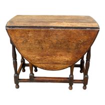 A 17th century style oak drop leaf table, the oval mounted top on square and turned legs joined by