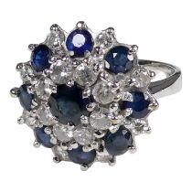 An 18ct white gold diamond and sapphire ring - with a stepped cluster form, size M, weight 7.9g.