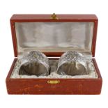 A pair of white metal napkin rings - with naturalistic embossed decoration, cased.