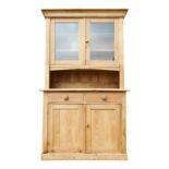 A Victorian pine dresser - the raised back with a pair of glazed panel doors, the base with an