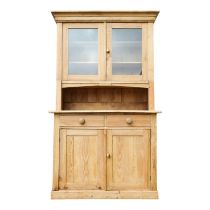 A Victorian pine dresser - the raised back with a pair of glazed panel doors, the base with an