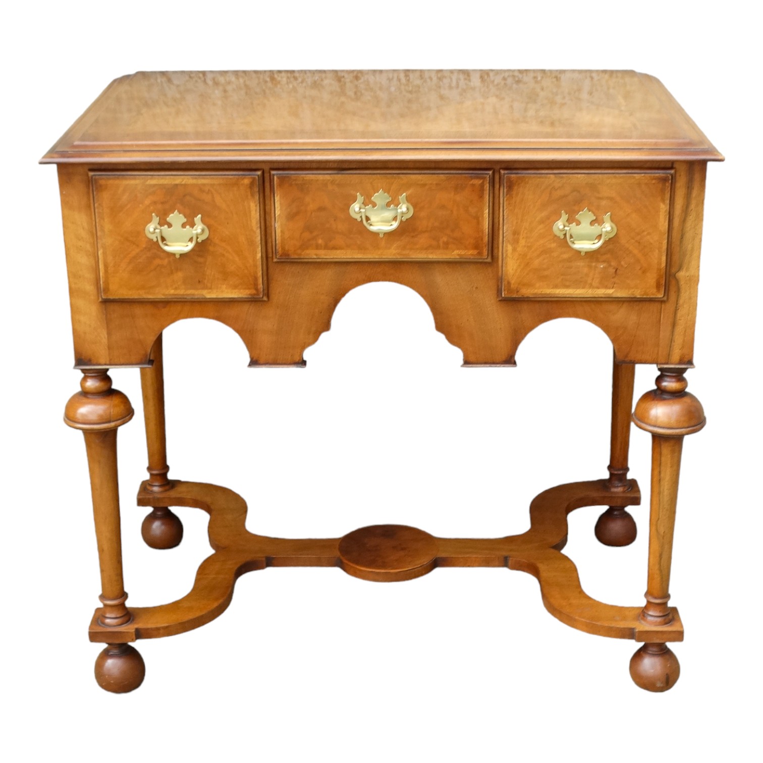 A walnut William and Mary style lowboy - the rectangular moulded top with cross banding above an