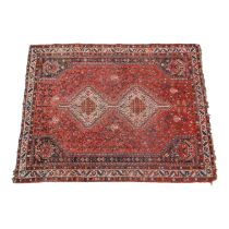 A Persian rug - with a pair of central diamond guls on a red foliate ground incorporating blue