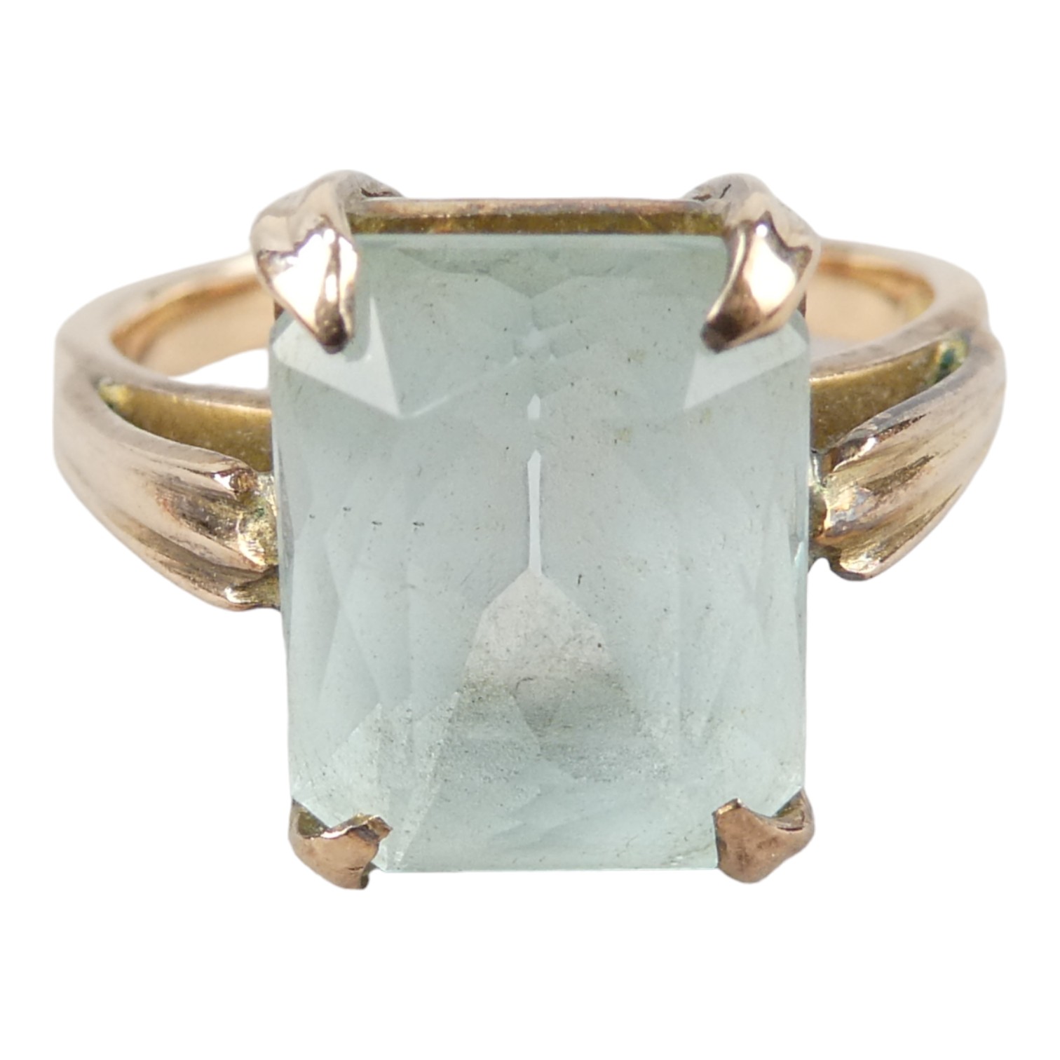 A 15ct gold ring - claw set with an emerald cut light blue stone, size O, weight 4.8g.