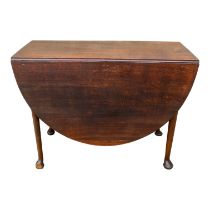 A George III oak drop leaf table - the oval top above a gateleg action, on turned legs ending in pad