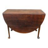 A George III oak drop leaf table - the oval top above a gateleg action, on turned legs ending in pad