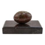 An early 20th century serpentine desk weight - in the form of an egg raised on a rectangular base,