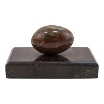 An early 20th century serpentine desk weight - in the form of an egg raised on a rectangular base,