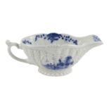 An 18th century blue and white sauce boat - ex Watney Collection, moulded decorations with landscape