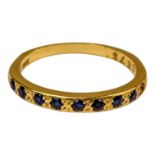 An 18ct yellow gold half eternity ring - set sapphires, size L, weight 2.1g.