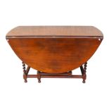 An early 20th century walnut oval drop leaf table - in the 17th century style, with barley twist