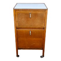 An early 20th century oak 'hospital' bedside cupboard - with a Formica top above two cupboards