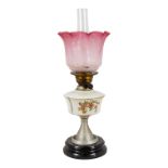 A late Victorian oil lamp - the milk glass reservoir decorated with flowers and an etched glass