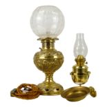 An early 20th century brass oil lamp - with foliate repousse reservoir and etched glass globe,