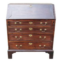 A George III mahogany bureau - the cleated fall enclosing a fitted interior above an arrangement