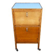 An early 20th century oak 'hospital' bedside cupboard - with a Formica top above two cupboards