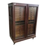 An oak collector's cabinet - with a pair of glazed panel doors enclosing an arrangement of