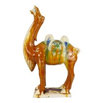 A Chinese Tang style camel - the saddle bags modelled as face, 62cm high