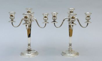 A pair of silver four-armed candlesticks , signed Sauvage
