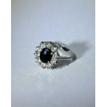 White gold women's ring with sapphire surrounded by diamonds
