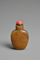 A CHINESE AGATE STONE SNUFF BOTTLE. Of flattened ovoid form carved in relief with peony spray.