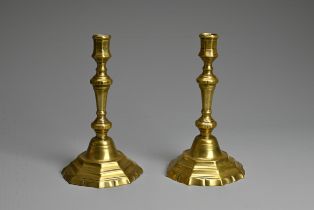 A PAIR OF 19TH CENTURY BRASS BALUSTER CANDLESTICKS. Each with faceted nozzle and tapering column
