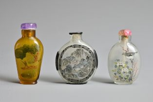 THREE CHINESE GLASS SNUFF BOTTLES. To include an inside painted bottle with black overlay, decorated