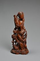 A CHINESE CARVED BOXWOOD FIGURE OF GUANYIN. Well carved depicting figure of Guanyin next to a girl