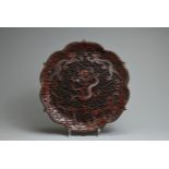 A CHINESE RED LACQUER DRAGON DISH, 19/20TH CENTURY. With bracket lobed rim finely carved in relief