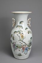 A CHINESE FAMILLE ROSE PORCELAIN VASE, 20TH CENTURY. Of baluster form with pierced gilt handles,