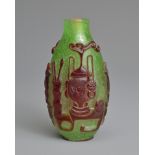 A CHINESE RED OVERLAY GREEN GLASS SNUFF BOTTLE, QING DYNASTY. Of ovoid form with red overlay in