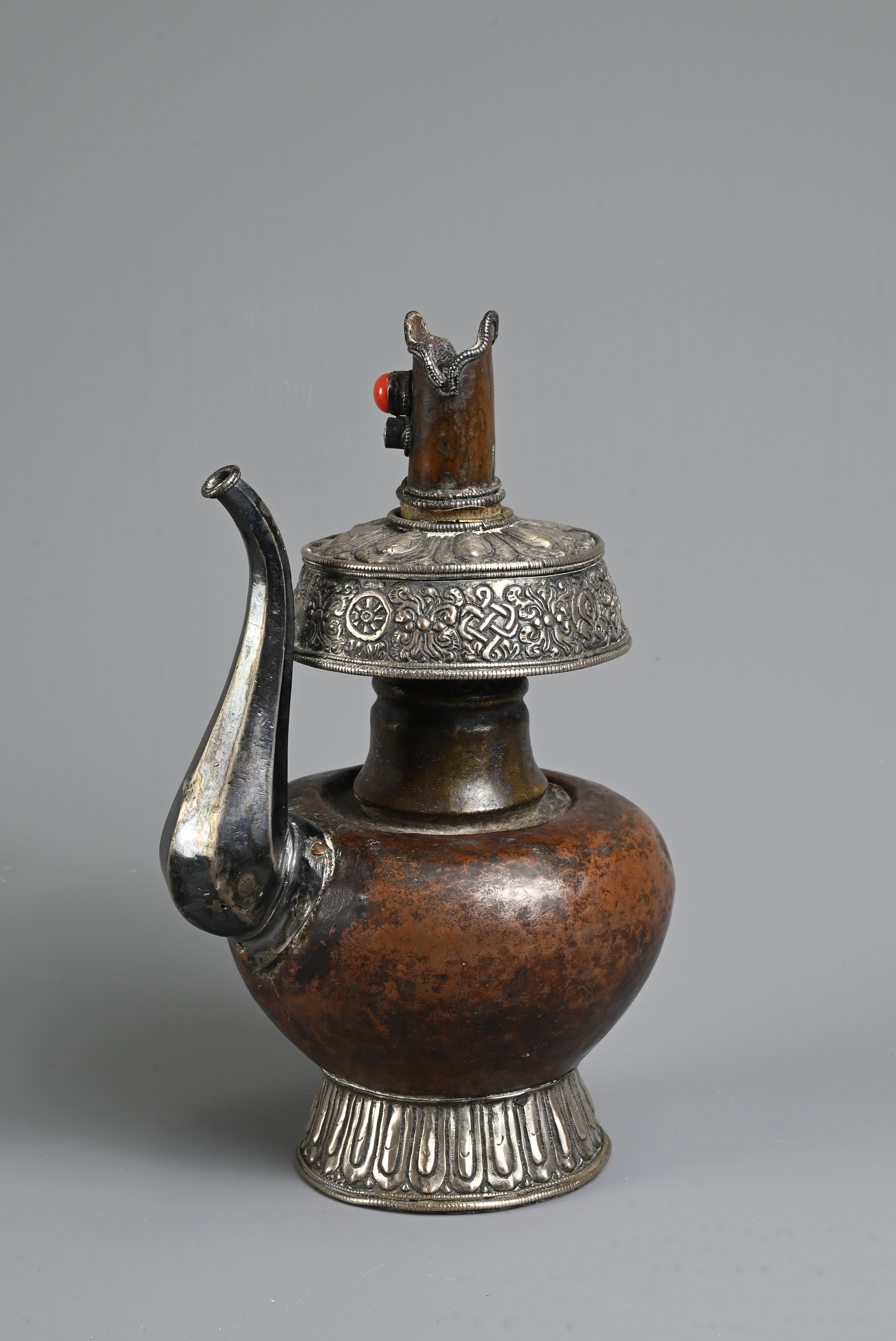 A TIBETAN COPPER AND SILVER EWER, BUMPA, 19/20TH CENTURY. With copper body and splayed silver foot