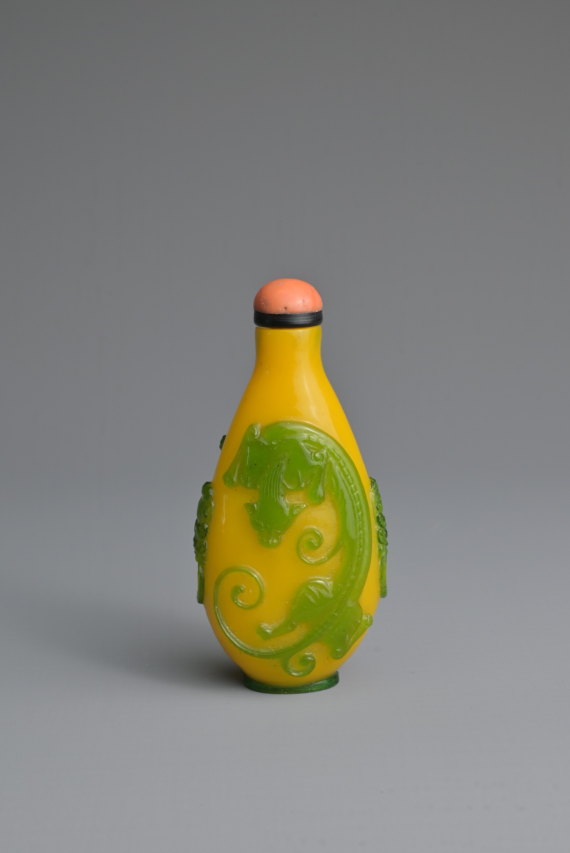 A CHINESE GREEN OVERLAY YELLOW GLASS SNUFF BOTTLE, QING DYNASTY. Of ovoid form with twin lion mask - Image 2 of 7