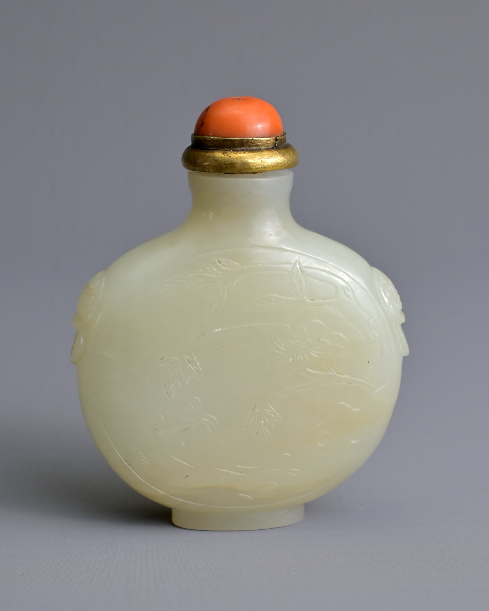 A CHINESE PALE CELADON JADE SNUFF BOTTLE, 19/20TH CENTURY. Of flattened globular form carved in