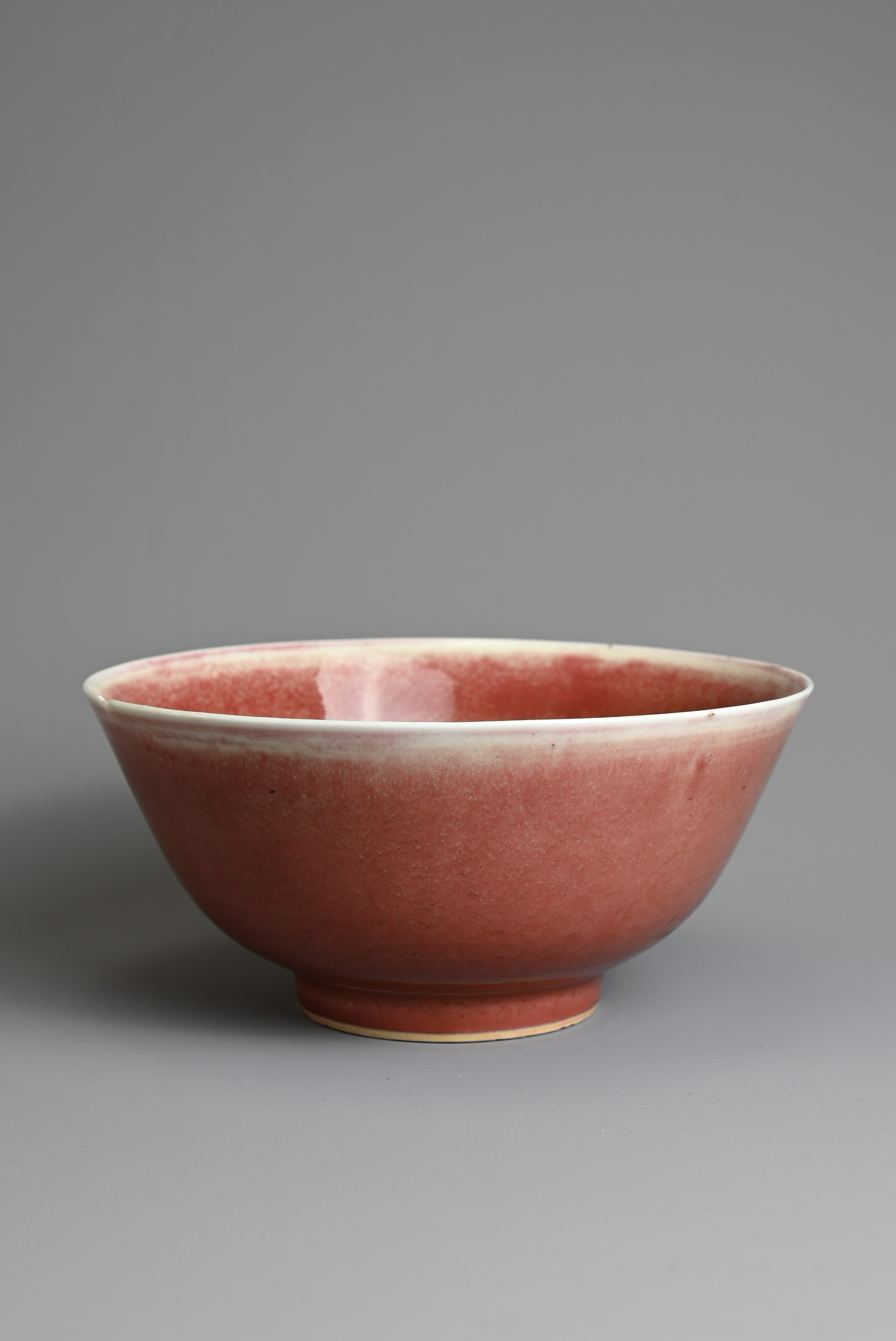 A CHINESE PEACH BLOOM GLAZED PORCELAIN BOWL, 18TH CENTURY. Rounded body with a gently everted rim
