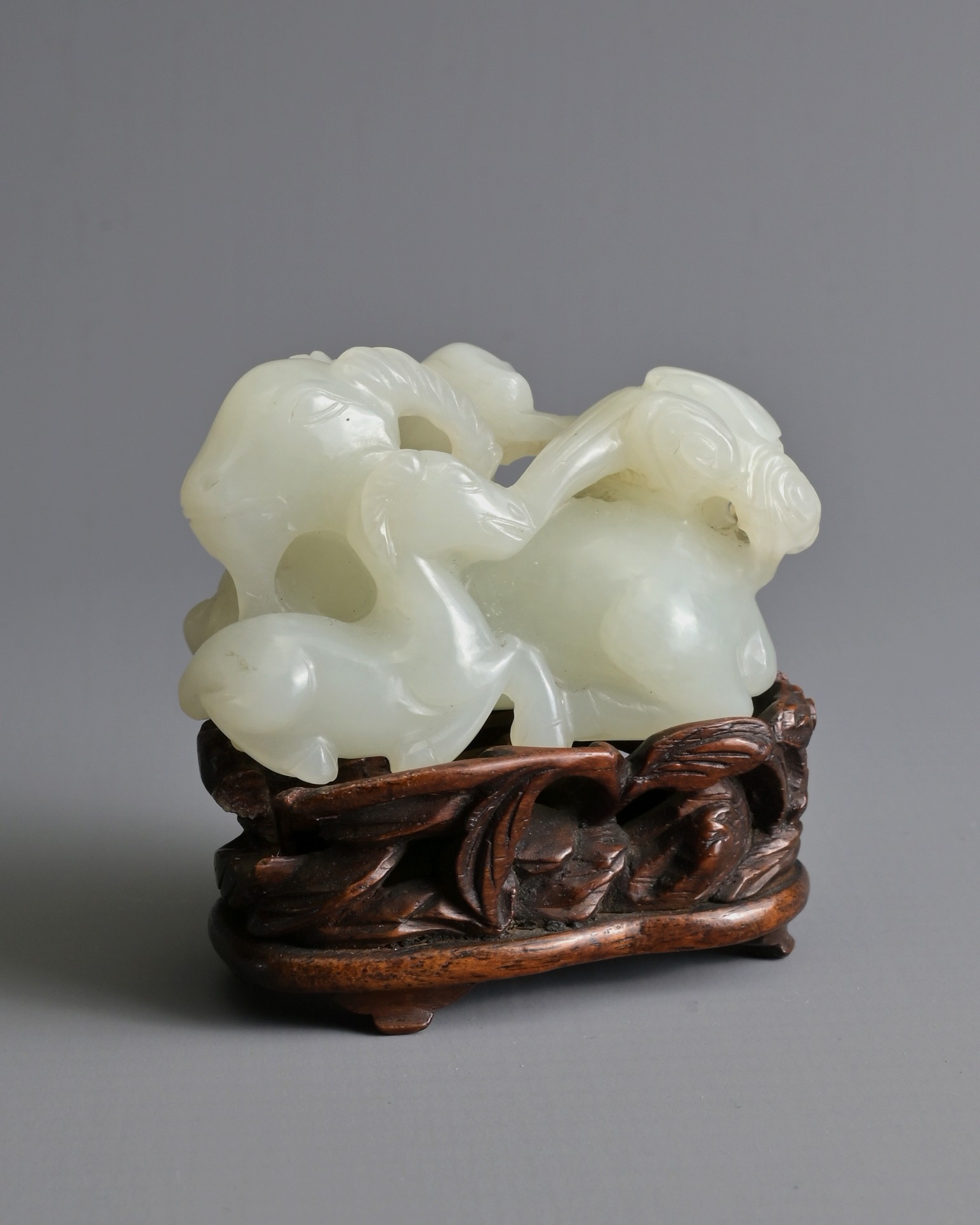 A CHINESE WHITE JADE DEER GROUP ON WOODEN STAND, 19/20TH CENTURY. Carved and pierced in the form