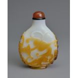 A CHINESE AMBER OVERLAY GLASS SNUFF BOTTLE, QING DYNASTY. Of flattened ovoid form featuring