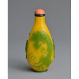 A CHINESE GREEN OVERLAY YELLOW GLASS SNUFF BOTTLE, QING DYNASTY. Of ovoid form with twin lion mask