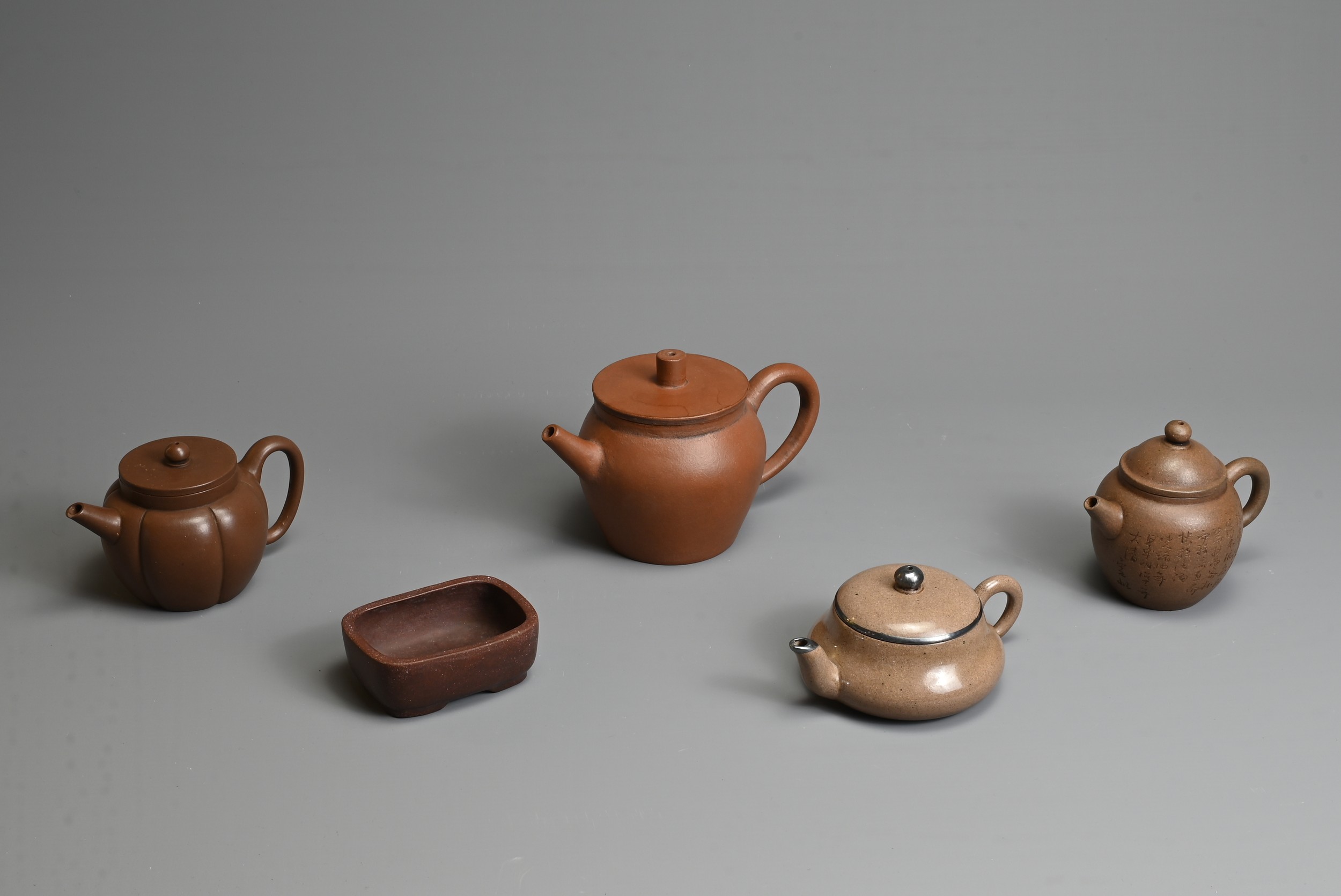 A GROUP OF CHINESE YIXING POTTERY, 20TH CENTURY. To include four teapots of varying forms each