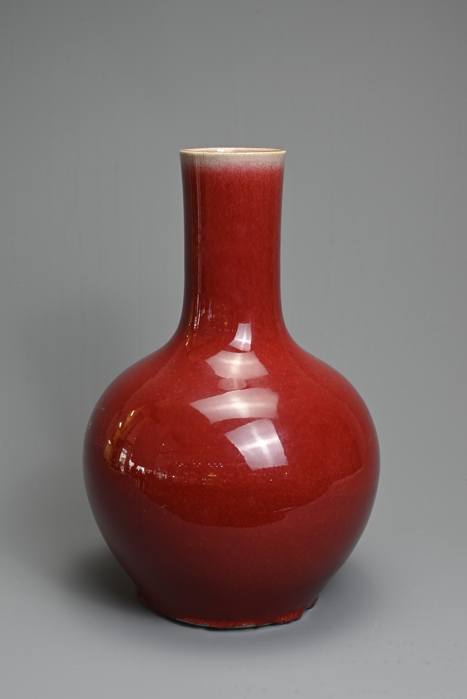 A CHINESE SANG DE BOEUF GLAZED PORCELAIN VASE, 19/20TH CENTURY. Globular bottle with tall