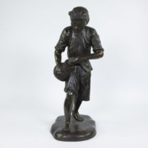 Large bronze statue of an Asian man with basket