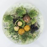 Large antique dish in barbotine with fruit and grape leaves