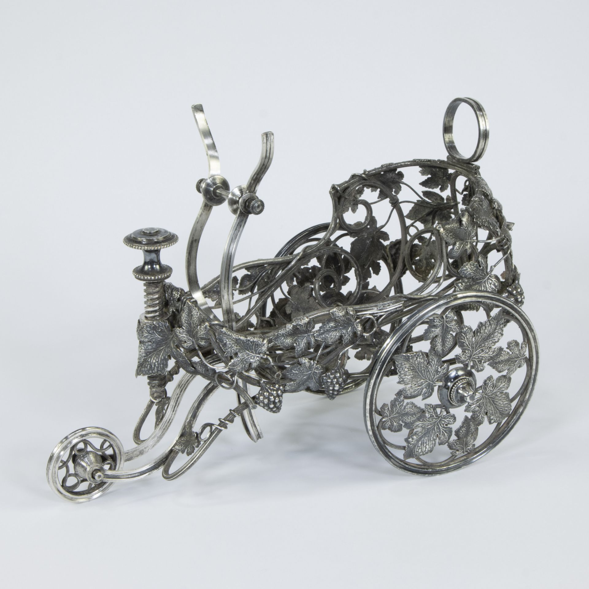 A French large silver-plated bottle chariot on three wheels, decorated with vines and grapes